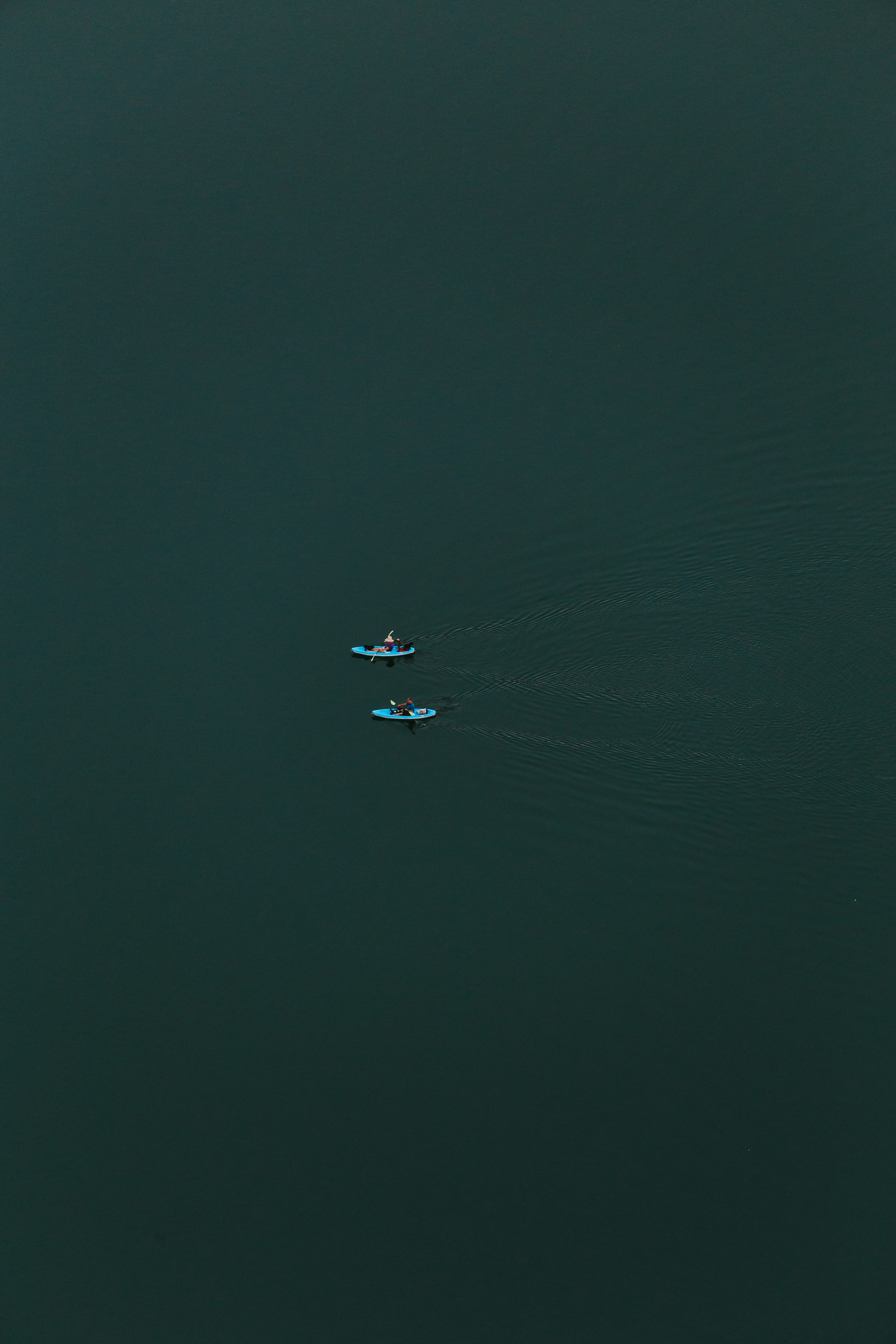 two people kayaking at calm body of water